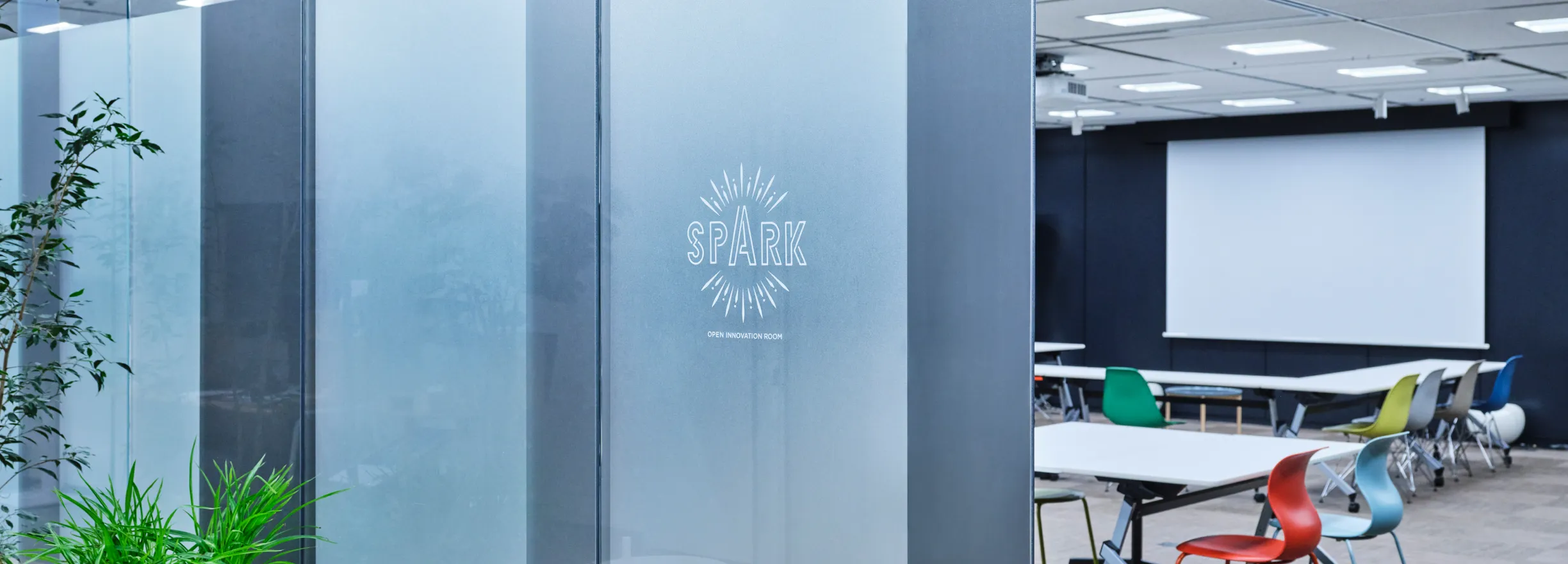 An open innovation room with a glass partition that reads "SPARK."