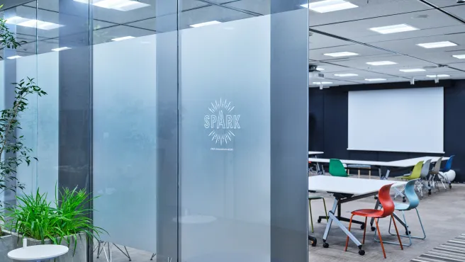 An open innovation room with a glass partition that reads "SPARK."